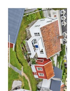 Fotografi av en hvit og rød bygning sett fra luften (helikopter eller drone).