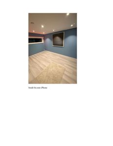 Fotografi av et innvendig rom med blåmaling, lyse gulv og en gulvteppe.