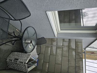 Fotografi av en uteplass eller balkong med møbler og en fasade.