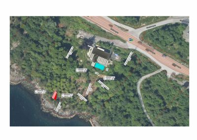 Satellittbilde (flyfoto) av et område med en bygning, vei og kystlinje, med overlagte koordinater og eiendomsgranser.