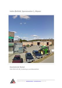 Fotografi av en industriell eller lagerbygning med parkerte biler og traktorer på en plass.