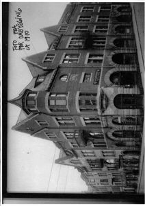 Et svart-hvitt fotografi av en fleretasjes bygning, tatt ca. 1910.