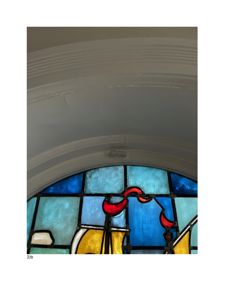 Fotografi av en farget glassvindu (klosterglass) med et bueformet rammeoverkant.