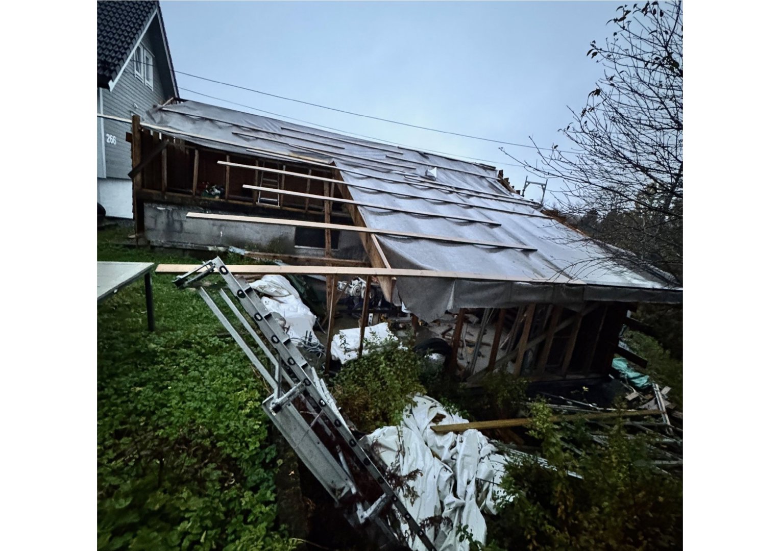 Fotografi av en bygning under ombygging eller reparasjon, med synlig takkonstruksjon og utstyr.