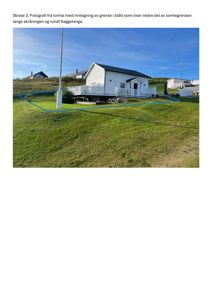 Fotografi av en hvit hytte på en skråning med en blå tegnet linje som markerer tomtegrensen.