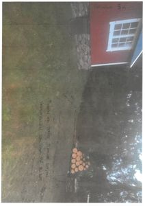 Fotografi av en tomt med en rød bygning i bakgrunnen, med håndskrevne notater om tomtens status.