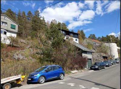 Fotografi av eksisterende bygninger og omgivelser sett fra en vei.