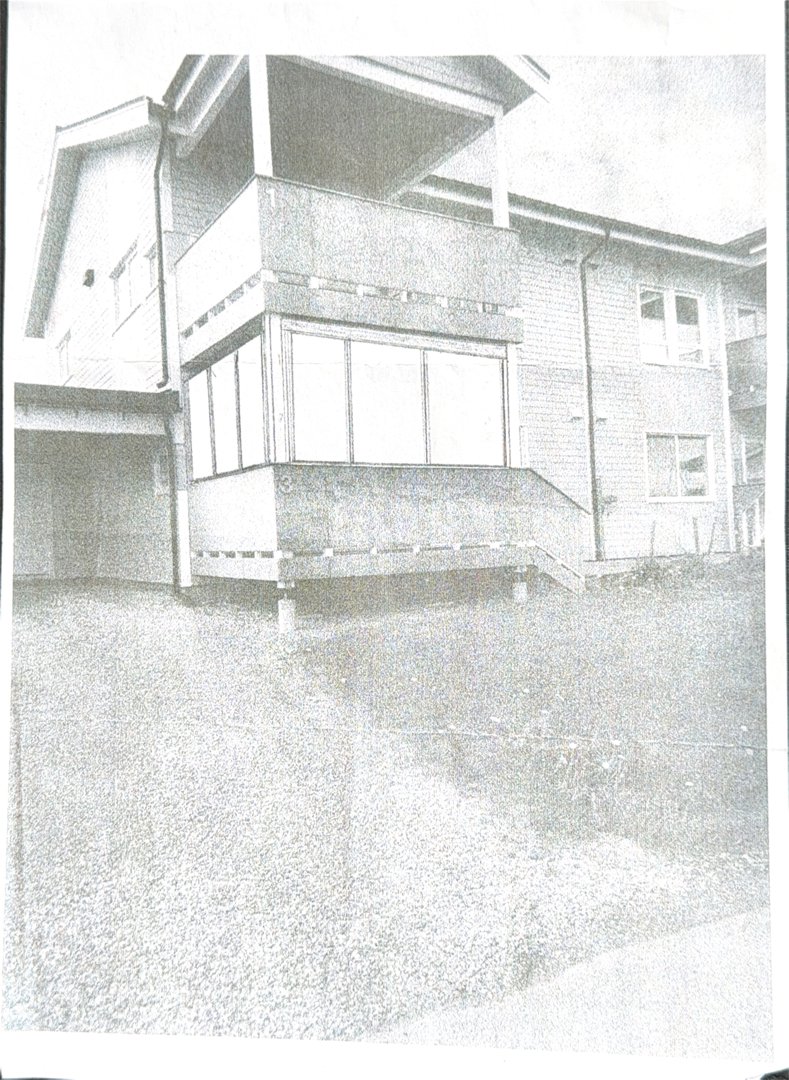 Fotografi av en bygning sett fra siden, som viser fasade, vinduer og etasjer.