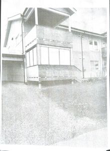 Fotografi av en bygning sett fra siden, som viser fasade, vinduer og etasjer.