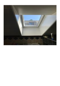 Fotografi av et takvindu sett fra innsiden av et rom.