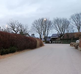 Fotografi av en vei med hus i bakgrunnen.