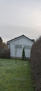 Fotografi av en hvit bygning sett fra bakgården.