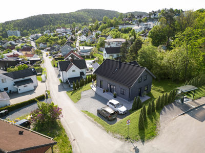 Luftfoto av et boligområde med fokus på en grå hytte.