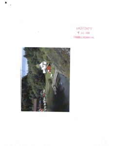 Fotografi av en eksisterende bygning (hus) sett fra luften eller en høyde, med omgivende natur og vann.