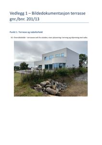 Fotografi av en moderne hvit bygning med terrasse, sett fra utsiden. Bildet viser plassering i terrenget og nabolag.