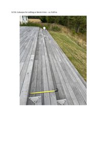 Fotografi av en utvendig terrasse med en gul målebånd som ligger på bordplanken. Bildet viser en fysisk lokasjon for en måling.