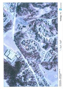 Flyfoto eller satellittbilde av et boligområde med en markert bygning (rødt sirkel) og omgivende infrastruktur.