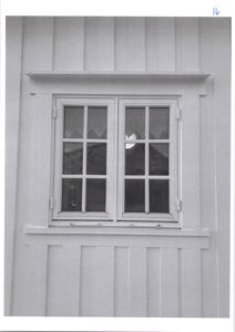 Fotografi av en fasade med et vindu i trepanelvegg.