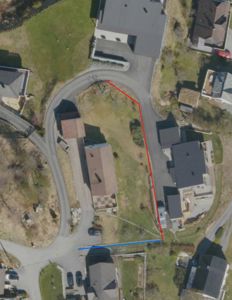 Flyfoto eller satellittbilde av et nabolag med en markert tomt (rød og blå linje).