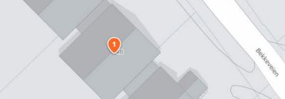 Et digitalt kart med en bygning markert med et lokasjonssymbol og gatenavn 'Bekkeveien'.