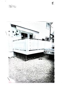 Fotografi av en terrasse med balustrade og en bil parkert ved siden av.