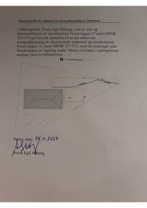 Situasjonsplan som viser eiendomsgrenser, en bygning (HYTTE) og en støttemur.