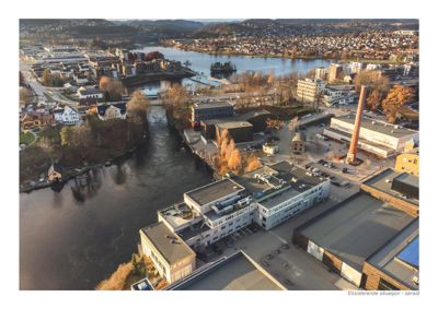 Et fotografi som viser en eksisterende situasjon (sørøst) med bygninger, vann og omgivelsene.