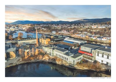 Et fotografi som viser en eksisterende bygning og omgivelsene sett fra sørvest.