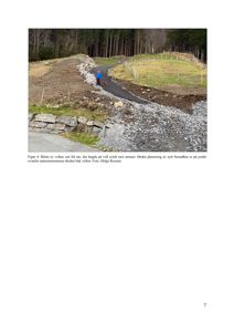 Fotografi av en vollen sett fra sør, med en person og hund på en sti, og en natursteinsmur i bakgrunnen.