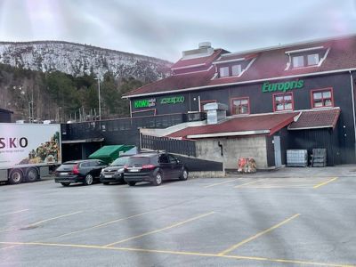 Fotografi av en eksisterende bygning (Europris) sett fra parkeringsplassen.