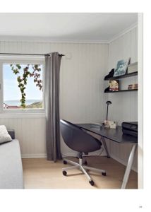 Fotografi av et innredet rom, sannsynligvis et kontor eller et stueområde, med skrivebord, stol og vindue.