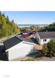 Fotografi av en bolig og garasje på en tomt med utsikt over vann og fjell.