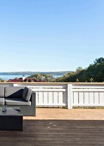 Fotografi av en terrasse med utsikt over vann og fjell.