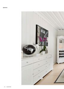 Fotografi av en innredet spisestue med hvite møbler og dekorasjoner.