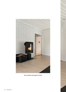 Fotografi av en innendørs stue/spisestue med hvitmalt klinkervegg, peis og gulv.