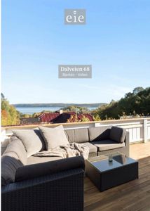 Fotografi av en terrasse med utsikt over vann og landskap, med møbler og tekstopplysning.