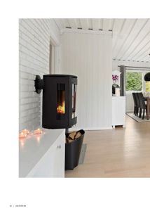 Fotografi av et interiør i en bolig, som viser en peis, hvite vegger og et spisestueområde.