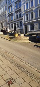 Fotografi av fasaden på en fleretasjes bygning sett fra gaten.