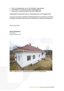 Fotografi av en eksisterende hvit bygning med rødt tak og hvite benker foran, tatt fra et lavt vinkel.