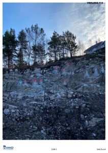 Fotografi av en steinmur eller bergvegg med markerte punkter og en tekstlinje.