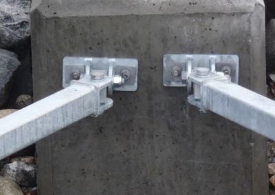 Fotografi av en detalj på en bygning, der metallstenger er festet til en betongkonstruksjon.