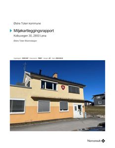 Fotografi av en gult og oransje malt bygning (Østre Toten Brannstasjon) sett fra siden.