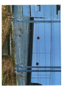 Fotografi av en bygning sett gjennom et gjerne, med en snittet oppstilling.