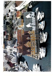 Fotografi av en havn med båter og bygninger sett fra luften.