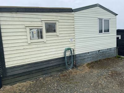 Fotografi av en bygning sett fra siden, som viser fasaden, vinduer, tak og grunnmur.