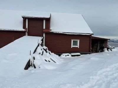 Fotografi av en rød, snødekt bygning sett fra siden.