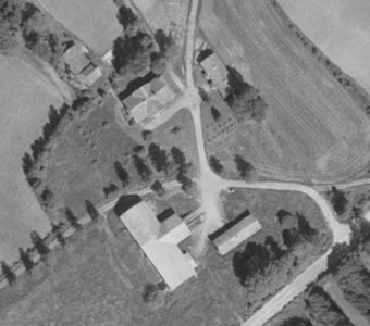 Flyfoto eller ortofoto som viser en bygning og omgivelsene sett fra luften.