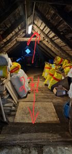 Fotografi av et loft eller kjellerrom med skrå tak, hvor det er markert en høyde på 2,71 meter med røde piler.