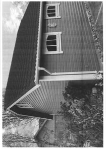 Fotografi av en bygning sett fra siden, som viser fasade, tak, vinduer og omgivelser.