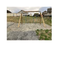 Fotografi av en utendørs lekapparat (sveiper) på en betongplate, med boliger i bakgrunnen.